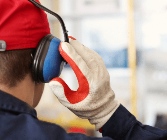 man with gloves holding his earmuffs on his head