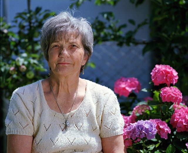 An elderly lady smiling gently,with discreet hearing aid